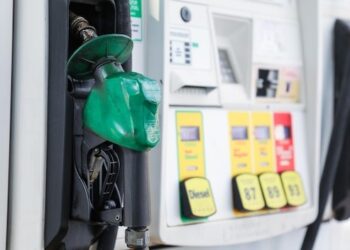gas pump nozzle with rising numbers on the display symbolizing inflation and escalating gas prices