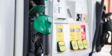 gas pump nozzle with rising numbers on the display symbolizing inflation and escalating gas prices