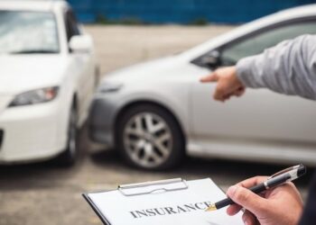 Cropped hand of insurance agent by customer gesturing at car