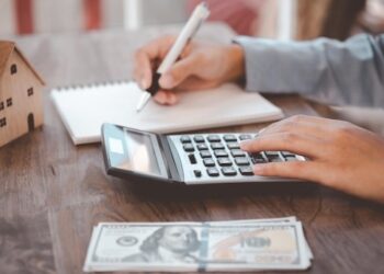Close up of woman Using a calculator to calculate and plan expenses in the house.