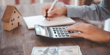 Close up of woman Using a calculator to calculate and plan expenses in the house.