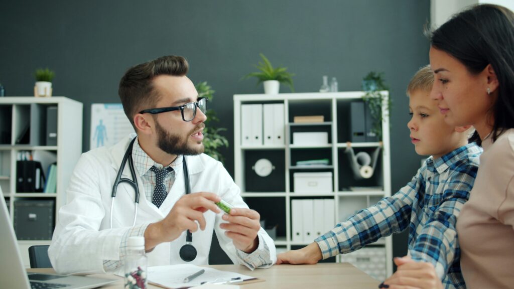 Doctor talks to mother and son in office.