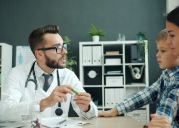 Doctor talks to mother and son in office.