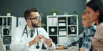 Doctor talks to mother and son in office.