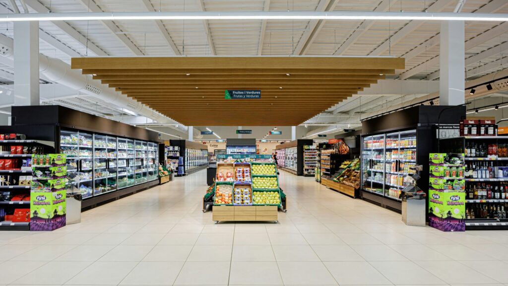 A brightly lit supermarket aisle with shelves of products.