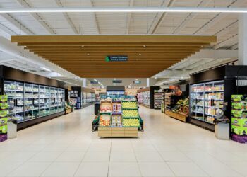 A brightly lit supermarket aisle with shelves of products.