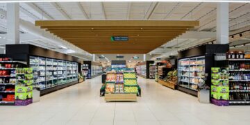 A brightly lit supermarket aisle with shelves of products.