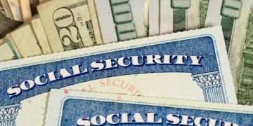USA Social security cards laid on dollar bills