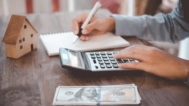 Close up of woman Using a calculator to calculate and plan expenses in the house.