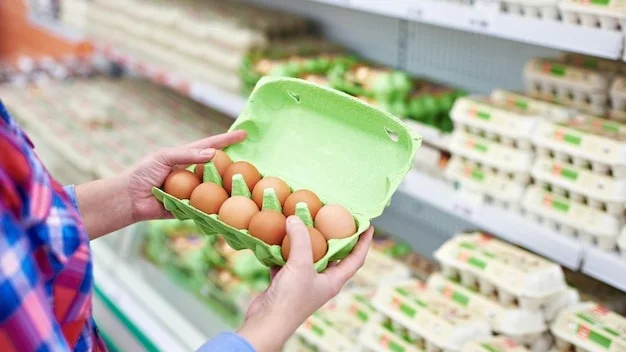 In the hands of a woman packing eggs in the supermarket